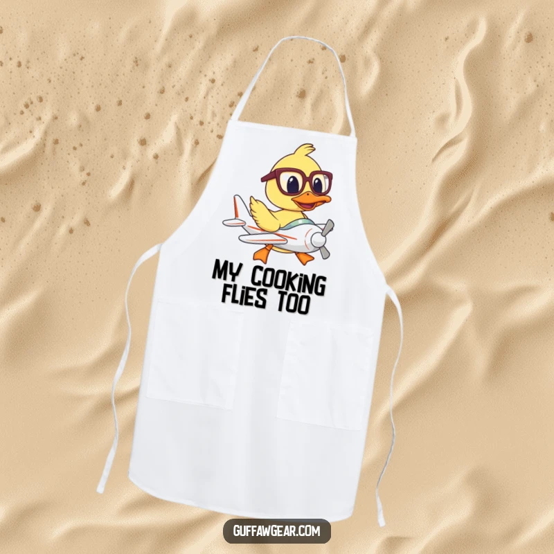 Funny apron featuring a duck pilot with oversized glasses, humorously struggling to fly a mini plane while cooking.