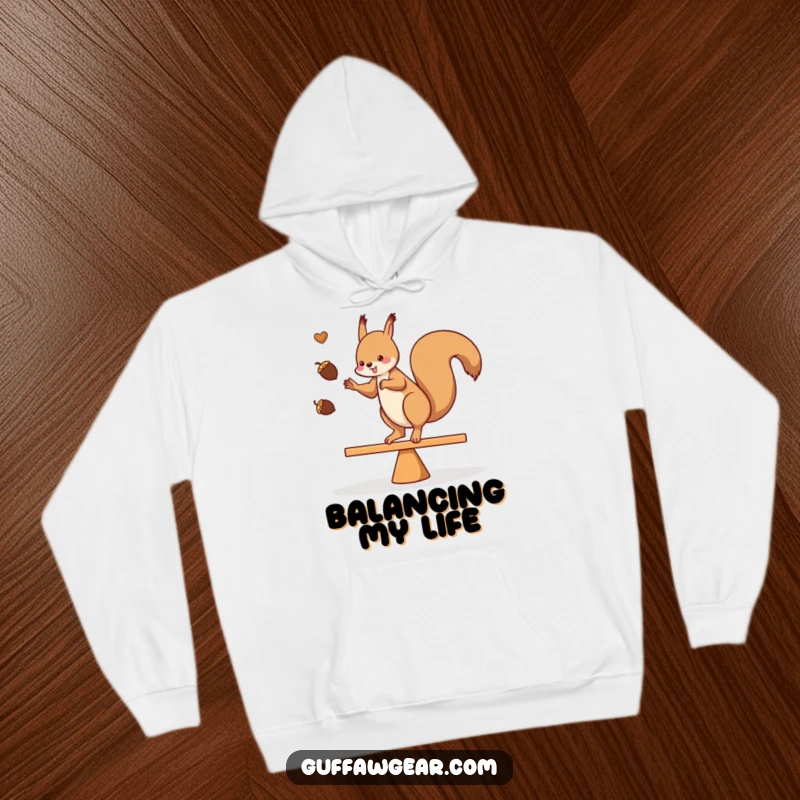 Funny hoodie featuring a squirrel juggling acorns while balancing on a teeter-totter, soft and warm for cozy days.