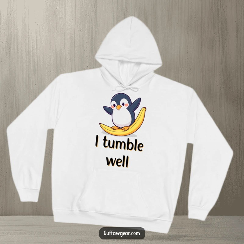 Funny and warm hoodie featuring a penguin in a dramatic, mid-air slip after stepping on a banana peel.